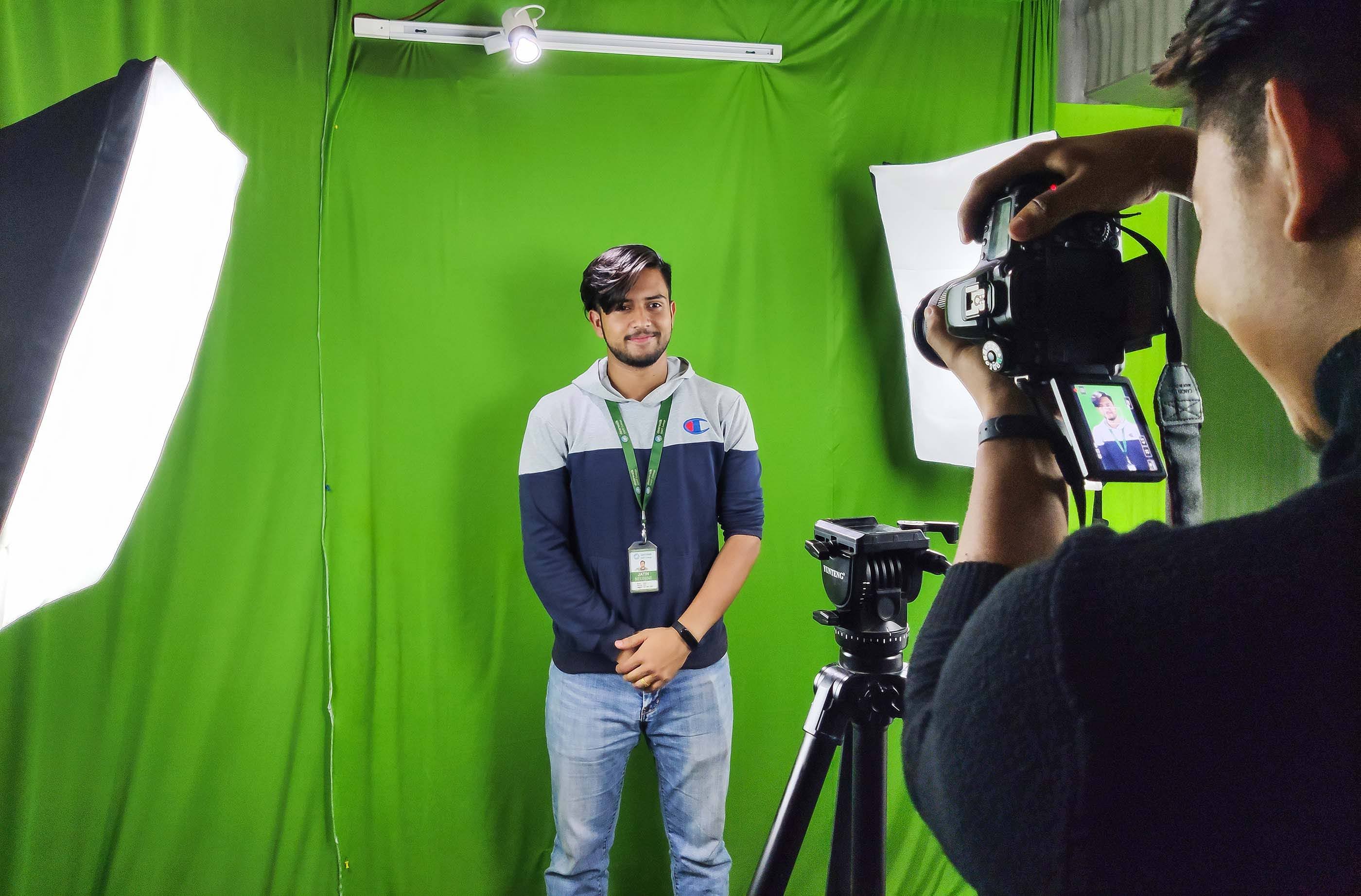 Intern at DMT clicking photo of a student in the studio 